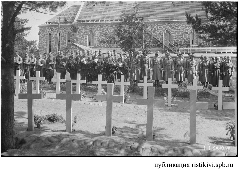 Церемония у воинского мемориала в годовщину занятия Кякисалми 21 августа. На заднем плане церковь / Käkisalmen valloituksen vuosipäivän 21.8. kunniaksi sankarihaudoilla. Taustalla pahasti runneltu kirkko Церемония у воинского мемориала в годовщину занятия Кякисалми 21 августа. На заднем плане церковь / Käkisalmen valloituksen vuosipäivän 21.8. kunniaksi sankarihaudoilla. Taustalla pahasti runneltu kirkko